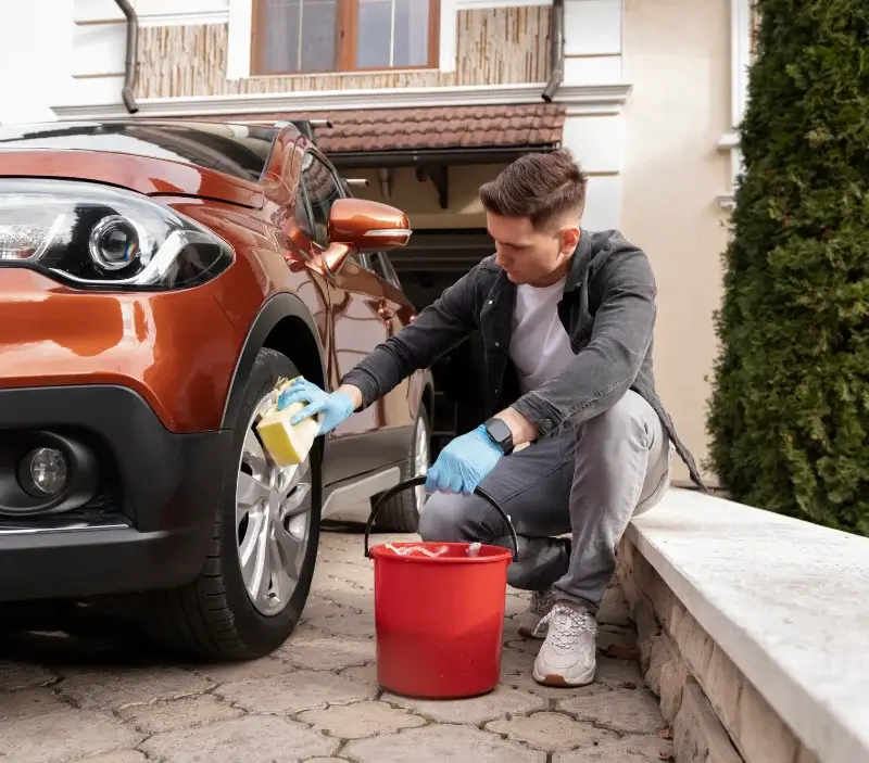 Lavage auto à domicile Plateau d'Hauteville : professionnel intervenant sur un véhicule